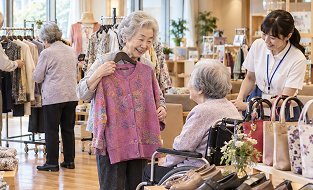 車椅子のご利用者様と一緒に洋服を選ぶ様子